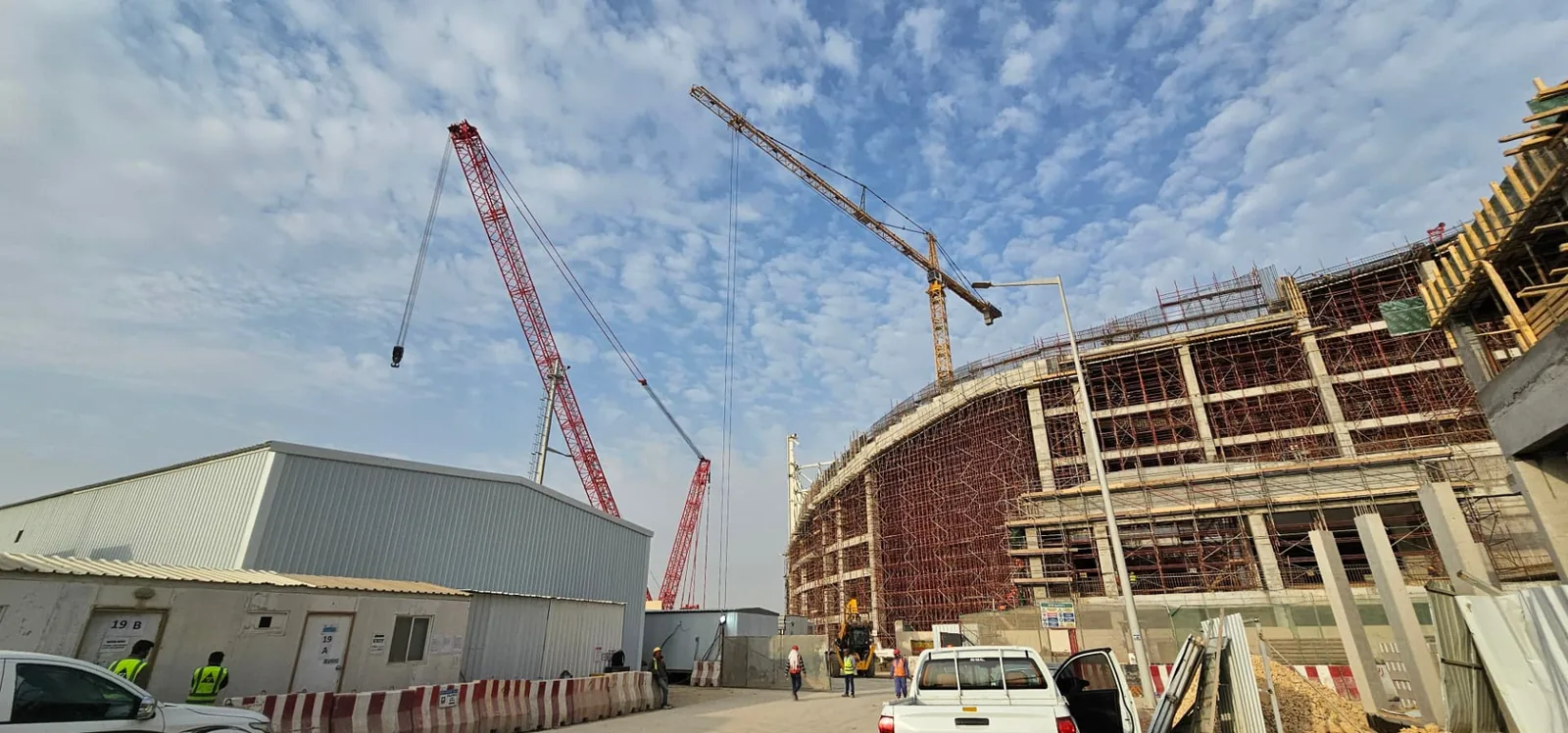 Active construction site with tower and crawler cranes under ARS safety oversight